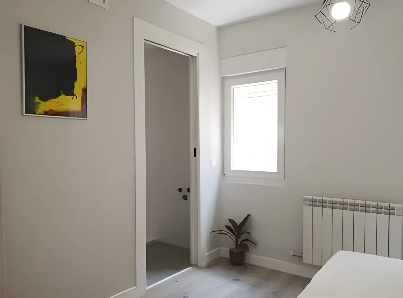 Habitación recién pintada en blanco por Los Pintores Getafe para comunidad de vecinos